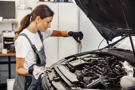 A skilled mechanic diligently works on a car engine inside a bustling auto repair shop environment