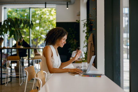 female working outdoors, lady studying in sunny cafe, woman researching campaign ideas in cozy cafeの写真素材