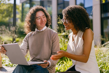 scholars exchange ideas outside campus, professionals analyze ecofriendly project plans outdoorsの写真素材
