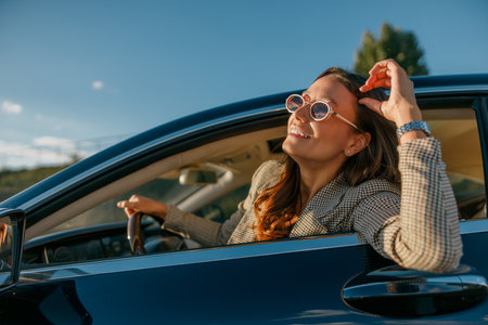 Sunny woman smiling with sunglasses during scenic journey at dusk