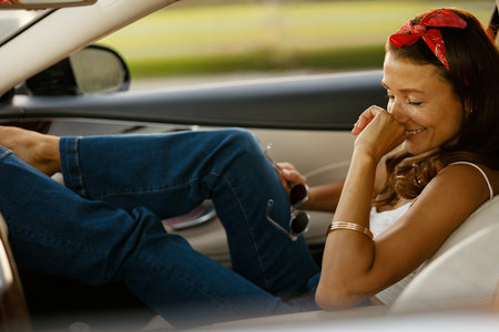 Calm female traveler soaking in sunset ambiance from car window seatの写真素材