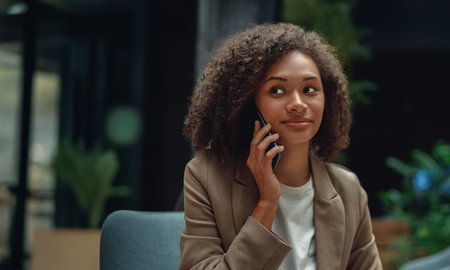 confident businesswoman speaking, professional woman on call, woman in blazer speaking confidently on phoneの写真素材
