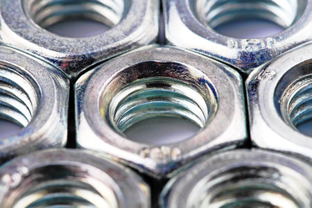 Coated steel nuts closeup on a white background.