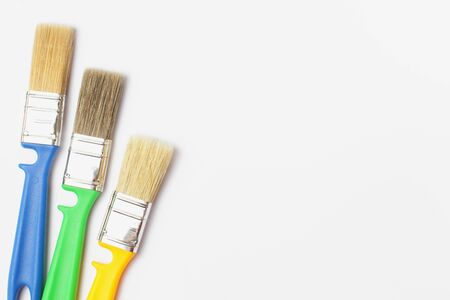 Paint brushes of different colors on a white background close-up, flat lay, place for text.の写真素材