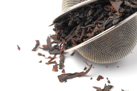 Tea strainer with tea leaves on a white background close-up,isolate.