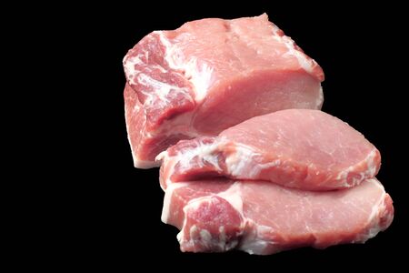 Large pieces of raw pork steak, close-up, black background, copy space, isolate.の写真素材