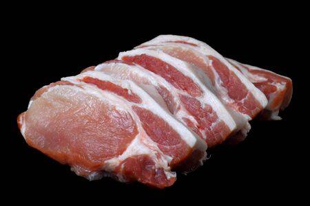 Large pieces of raw pork entrecote on a black background, concept for shop signboard or label.の写真素材