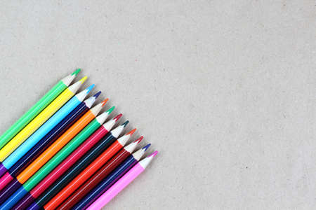 Colored pencils on a gray craft background, desktop. School or education theme concept. Top view, flat lay, place for text, copy space.の写真素材
