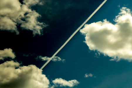 The with is divided by an airplane trail, distorted by dramatic deep blues. Concept of environmental...