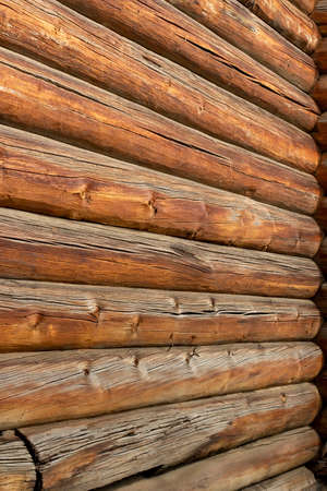 High wall of an old log house, round logs.の写真素材