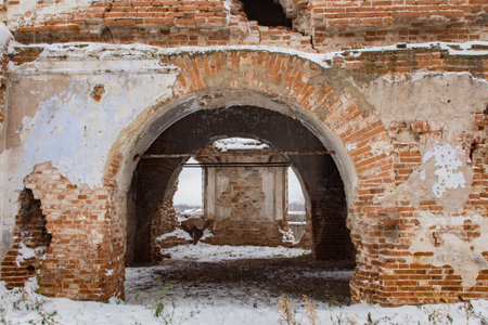 A huge arched doorway in an old abandoned brick building.
