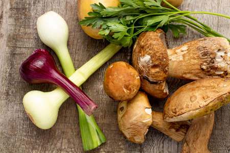 Set of products for a simple dish, potatoes with porcini mushrooms or Boletus edulis and onions on a rustic background.の写真素材