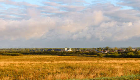 Autumn landscape. The old Orthodox church against the background of morning autumn bright colors and the sky with clouds.の写真素材