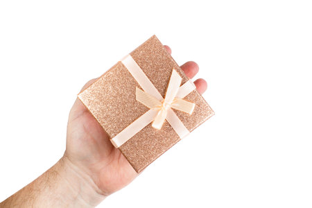 Golden box with a gift in a male hand on white isolated