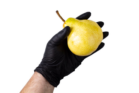 Ripe yellow pear on the hand of a man in a black glove on white isolateの写真素材