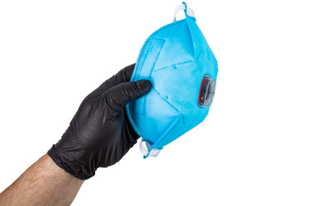 Respirator FFP3 for protection against viruses and dust in the hand of a man in a black glove on...