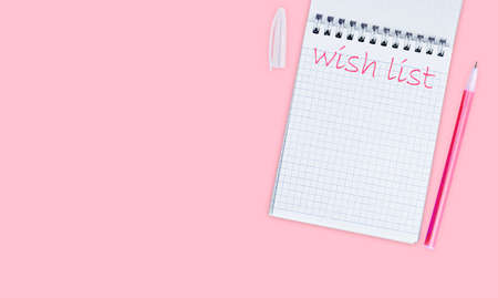 Notepad with the inscription Wishlist on a pink background top view, banner or flyer mockup, flat lay.の写真素材
