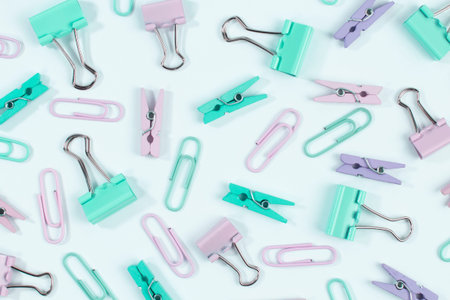 Pattern from assorted paper clips and stationery clips on white, flat lay.