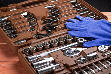 A set of tools for car repair and blue gloves of the master, box with tools, close-up.