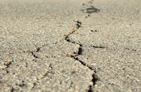 Close-up of a deep crack in the road surface.の写真素材