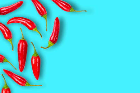 Frame of red hot chili peppers on a blue background close-up, place for text, top view, copy space.の写真素材