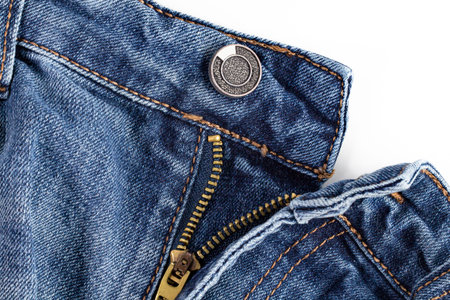 Opened zipper on worn jeans, close-up on white