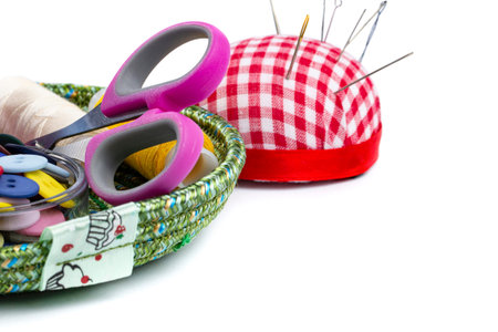 Sewing kit from needles, threads, buttons, scissors on white close-up, place for text, copy space.