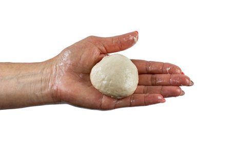 Female hand with a ball of dough on the palm, top view, close-up, on white isolated