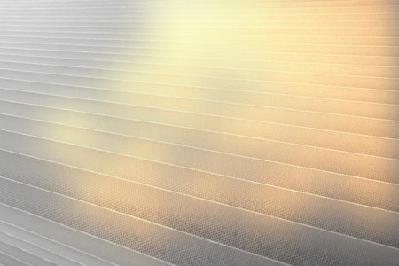 Window blinds with bright sunspots close-up.