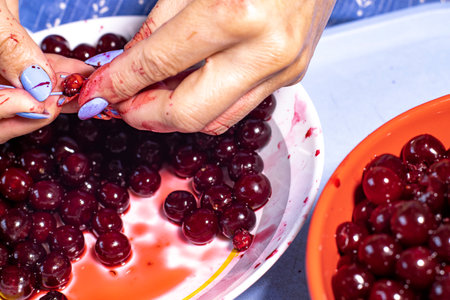 Woman removes bones from cherries, close-upの写真素材