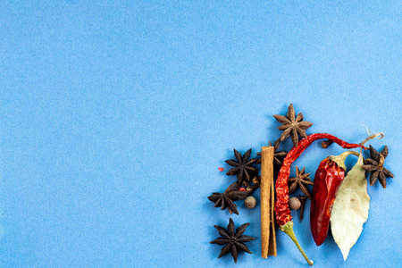 Fragrant herbs and spices frame on blue background, top view, layout for menu or food photo, copy...