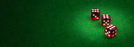 Three casino dice with winning numbers on green cloth, casino gambling, copy space.の写真素材