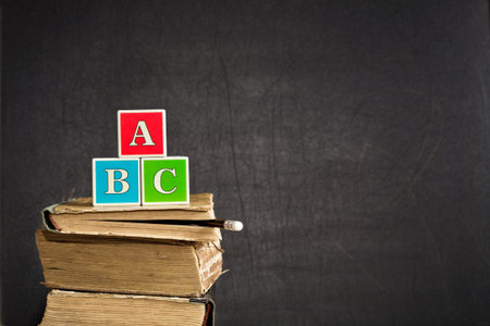 ABC on old textbooks against blackboard in classroomの写真素材