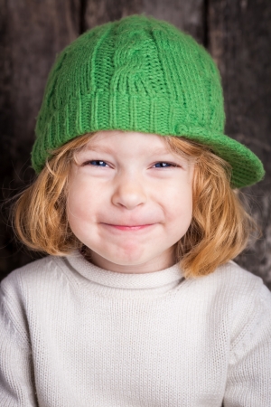 Funny smiling ginger kid in green hatの写真素材