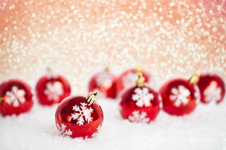 Christmas tree decorations on snow against lights backgroundの写真素材