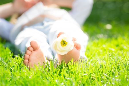 Closeup photo of children`s feet with flower in spring parkの写真素材