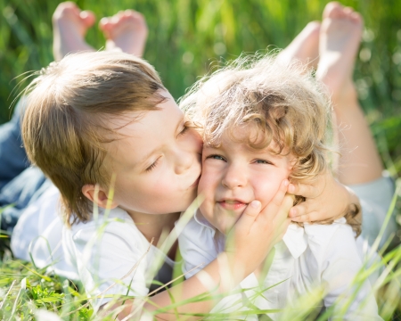 Happy children playing outdoors in spring grassの写真素材