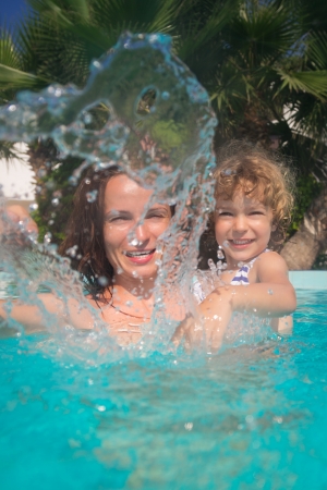 Happy family playing in swimming pool. Summer vacations conceptの写真素材
