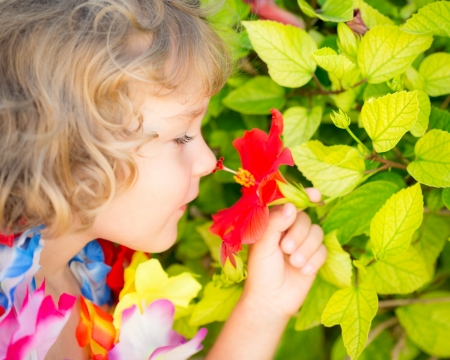 Happy child with tropic flower. Summer vacations conceptの写真素材