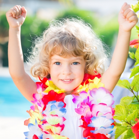 Happy child wearing hawaiian flowers garland on the beach. Summer vacations conceptの写真素材