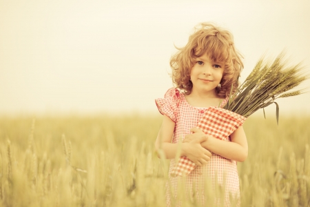 Happy child in autumn wheat fieldの写真素材