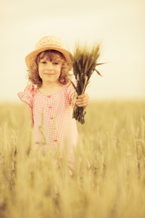 Happy child in autumn wheat fieldの写真素材