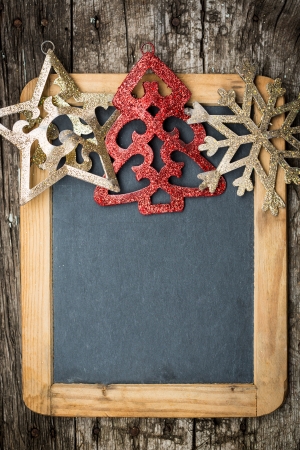 Christmas tree decorations border on vintage wooden blackboard  Winter holidays concept  Copy space for your textの写真素材
