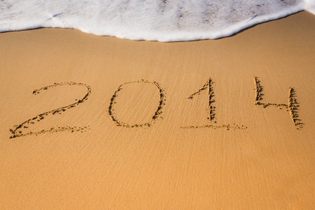 New Year 2014 is coming concept - text "2014" on a beach sand and sea waveの写真素材