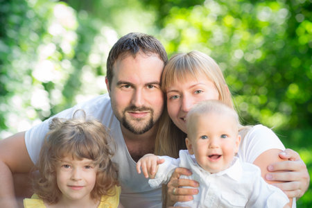 Happy family having fun outdoors against spring green background