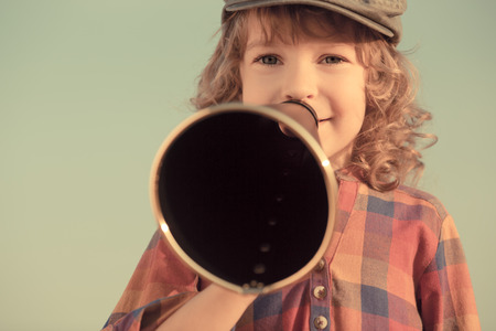 Kid shouting through vintage megaphoneの写真素材