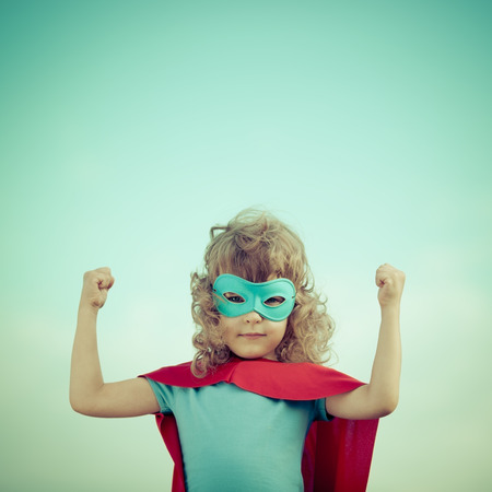 Superhero kid against summer sky background. Girl power and feminism conceptの写真素材