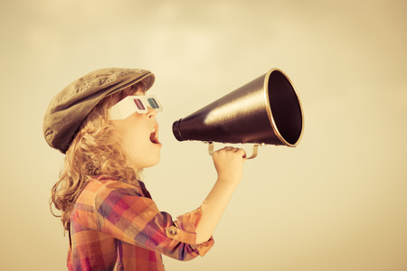 Child shouting through vintage megaphone