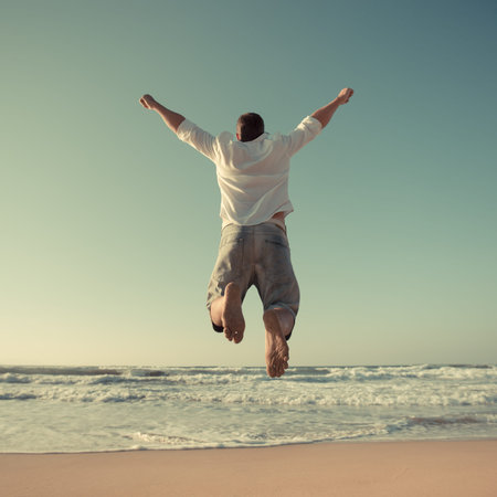 Funny man jumping at the beach. Travel and vacations concept