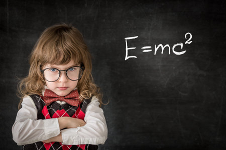 Smart kid in class. Happy child against blackboard. Education concept